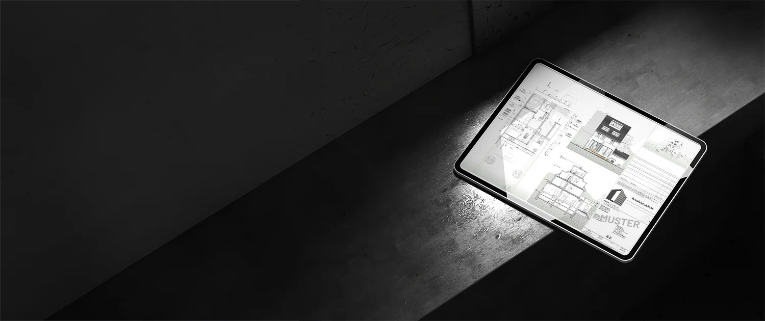 Eine Tafel mit architektonischen Entwürfen und Bauplänen liegt auf einer Betonfläche und wird von einem Lichtstrahl in einer ansonsten dunklen Umgebung beleuchtet.